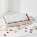Rose quartz facial roller with elegant packaging on white background